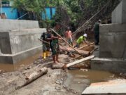 YAnggota Kodim 1505/Tidore Bersama Warga Gotong Royong Angkat Batang Kelapa untuk Penahan Jembatan Garuda