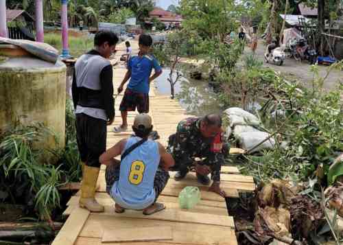 Babinsa Koramil 1002-05/Pandawan Gotong Royong Bantu Warga Perbaiki Titian di Desa Kayu Rabah